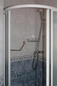 een badkamer met een douche met een douchekop bij Ferienwohnung in der Kaschubei, in ruhiger Lage am Waldrand, in der Nähe von Danzig und Sopot in Sulmin