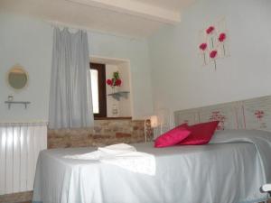 - une chambre avec un lit blanc et des oreillers rouges dans l'établissement Ferienwohnung Flieder, à Cagli