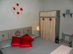 - une chambre avec un lit et des oreillers rouges dans l'établissement Ferienwohnung Flieder, à Cagli