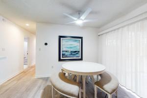 a white dining room with a table and chairs at Sea Colony- 52014 Canal in Bethany Beach
