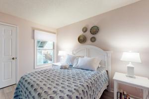 um quarto com uma cama com uma colcha branca e uma janela em Sea Colony- 52014 Canal em Bethany Beach