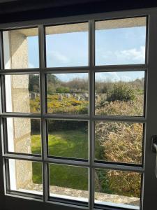 a window looking out at a view of a field at Maison vue sur les alignements de Carnac - Les Glycines in Carnac
