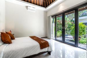 Un dormitorio con una cama y una ventana grande. en Anedda Merta Sari Villa Sanur, en Sanur