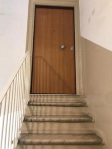 eine Treppe mit einer Holztür in einem Gebäude in der Unterkunft #pazzadite in Molfetta