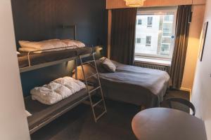 a small room with two bunk beds and a window at Danhostel Aarhus City in Aarhus