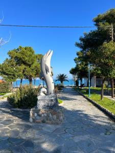 a statue of a dolphin on a rock at Jasmin Apartments in Hanioti