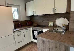 a kitchen with white cabinets and a sink at Ferienwohnung IDA in Peiting
