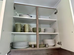 a pantry with plates and bowls on shelves at Ferienwohnung IDA in Peiting