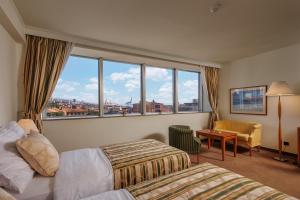 Habitación de hotel con 2 camas y ventana grande. en Grand Hotel Bonavia, en Rijeka