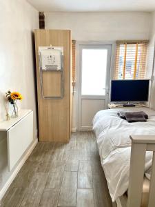 a bedroom with a bed and a desk with a computer at Rooms at EEJ homes in London