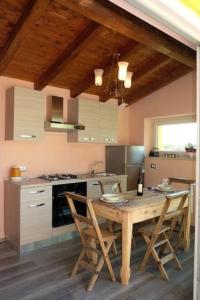 una cucina con tavolo in legno, sedie e piano cottura di Ferienwohnung für 4 Personen ca 70 qm in Gavardo, Gardasee Westufer Gardasee a Gavardo