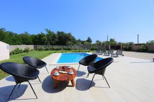 a patio with chairs and a table and a pool at Ferienhaus mit Privatpool für 5 Personen ca 80 qm in Loborika, Istrien Südküste von Istrien - b57678 in Loborika