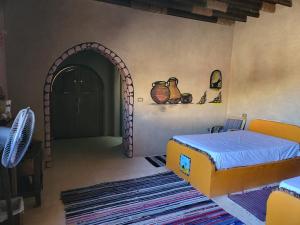 um quarto com uma cama e uma porta arqueada em Qasr El Bagawat Hotel em ‘Ezbet Halfa