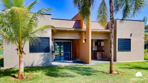 a house with two palm trees in front of it at Grandes Lagos Resorts e Parque Aquático in Santa Clara dʼOeste