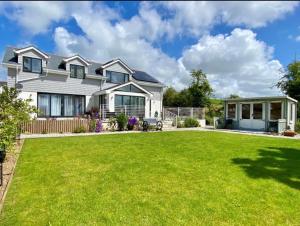 a large white house with a large yard at Lowen Chy 1 Green Hill in Wadebridge