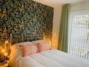 a bedroom with a bed with a floral wall at double room in Wadebridge