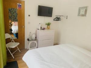 a bedroom with a bed and a tv on the wall at double room in Wadebridge