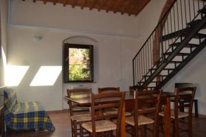 una sala da pranzo con tavolo, sedie e scale di Wohnung auf der ersten Etage a Campiglia Marittima