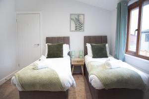 two beds sitting next to each other in a room at 3 Bedroom lodge with hot tub in York