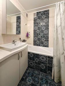 een badkamer met een wastafel, een bad en een douche bij Jungle Apartments in Vinnytsya