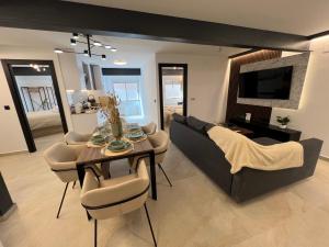 - un salon avec un canapé, une table et des chaises dans l'établissement AYQ Apartments BENIDORM BEACH 1, à Benidorm