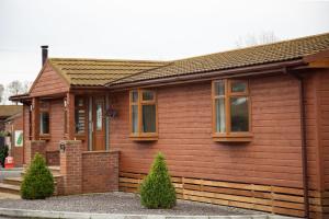 a small wooden house withwindows at 3 Bedroom lodge with hot tub in York +18 photos