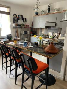 una cocina con una gran mesa de madera y sillas en Chez Mag en Lille