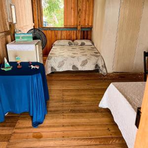 Cette chambre comprend 2 lits et une table. dans l'établissement Hostel Capitão da Ilha, à Maracanã