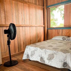 a bedroom with a bed in a wooden wall at Hostel Capitão da Ilha in Maracanã