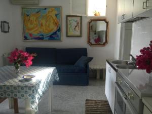 a living room with a blue couch and a table at Ferienhaus für 3 Personen 1 Kind ca 55 qm in Canneto auf Lipari, Sizilien Äolische Inseln in Lipari