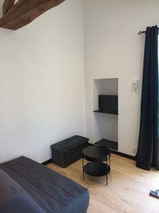 a bedroom with a bed and a table and a chair at Charmant logement atypique et calme in Mouchamps