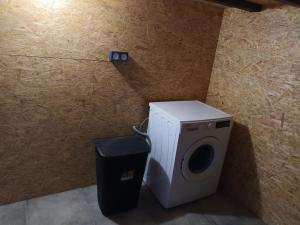 a washing machine and a trash can in a room at Charmant logement atypique et calme in Mouchamps