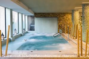 una piscina de agua en un edificio con nubes en Hotel AR Golf Almerimar, en Almerimar