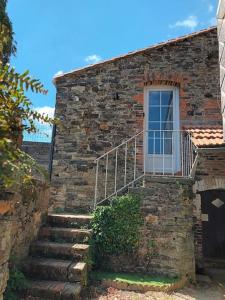 a stone building with stairs leading up to a door at Charmant logement atypique et calme in Mouchamps