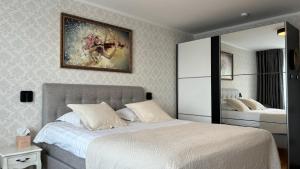 a bedroom with two beds and a painting on the wall at Promenaadi Apartment in Võru