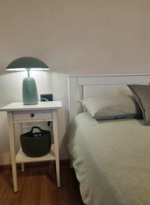 sypialnia z łóżkiem i stołem z lampką w obiekcie L'Oasi Amena - Camera Salvia w mieście Ameno
