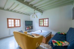 a living room with a couch and a table at Le Refuge du Bois d'Amour in Arnières-sur-Iton