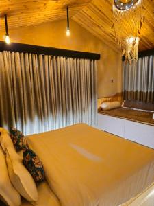 um quarto com uma cama grande em frente a uma janela em Hotel Old Manali - The Best Riverside Boutique Stay with Balcony and Mountain Views em Manali