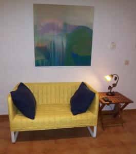 a yellow couch with two pillows sitting next to a table at Ferienwohnung für 2 Personen ca 25 m in Sencelles, Balearen Mallorca in Sencelles