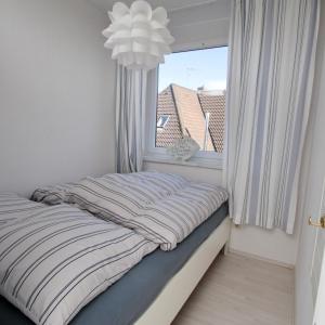 a bed in a room with a window at Schönes Appartement in Burhave in Butjadingen