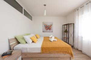 a bedroom with a bed with a teddy bear on it at Sunset Beach Suites in Kožino