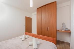 a bedroom with a bed and a wooden cabinet at Sunset Beach Suites in Kožino