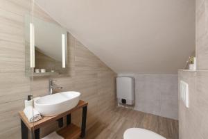 a bathroom with a sink and a mirror at Sunset Beach Suites in Kožino