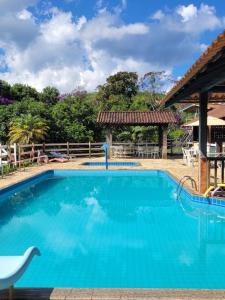 una piscina en un complejo con agua azul en Pousada Mirante Santo Antônio, en Rio Prêto