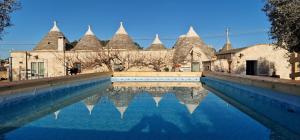 a pool of water in front of a building at Trulli Beauty LAMIA family pool in Martina Franca