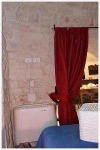 a room with a red curtain and a bed at Trulli Beauty LAMIA in Martina Franca