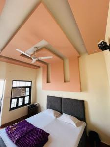 a bed in a room with a ceiling at Shimmer Farms in Faridabad