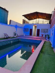 una piscina con luces azules en una casa en Shimmer Farms, en Faridabad