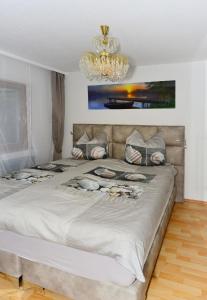um quarto com uma cama grande e um lustre em Ferienwohnung Appartement Seestern em Schluchsee