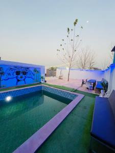 a swimming pool in the backyard of a house at Shimmer Farms in Faridabad